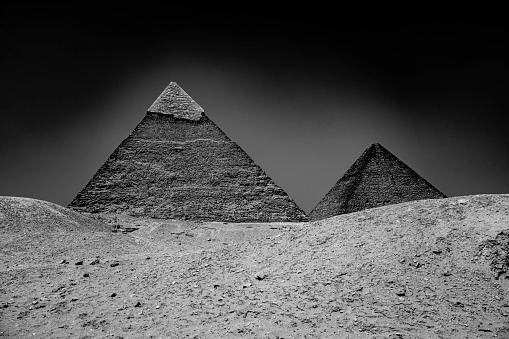 The pyramids with a blue sky in a desert area in black and white