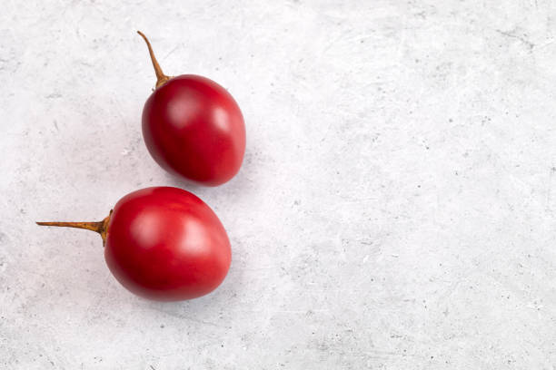 Closeup Fresh Tamarillo Fruit On Table. Egg-shaped Edible Fruit Known As Tree Tomato, Plant Family Solanaceae, Solanum Betaceum. Top View. Flat Lay. Copy Space For Text. Horizontal Plane.