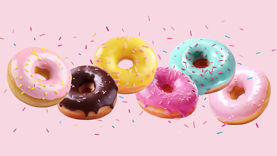 Assortment of falling or flying brightly colored donuts with falling sprinkles in motion against a pink background