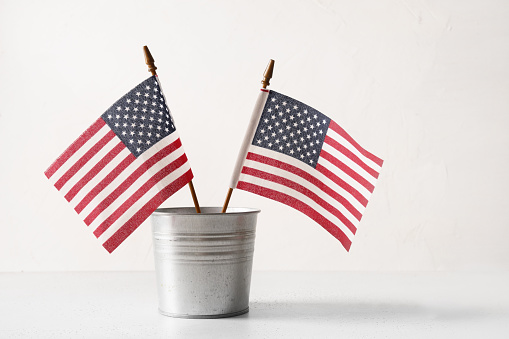 American flags in metal decorative bucket on white background. Concept , backdrop with copy space for USA Independence Day.