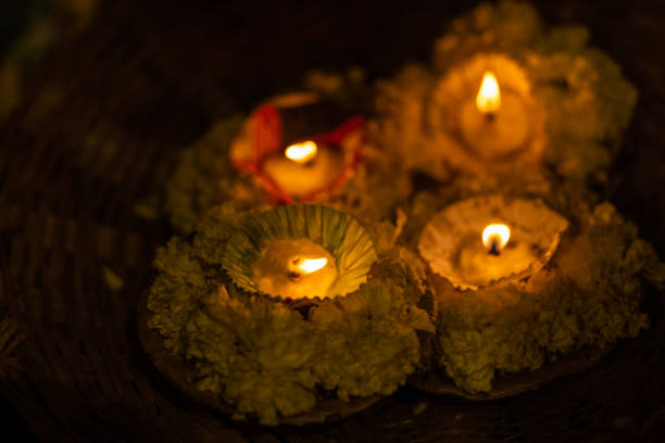 Diya candle floating in river ganges during night. Selective focus on flame.