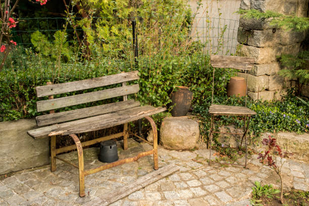 Old garden bench and chair in house garden