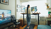 Woman at standing desk home office talking on business video call