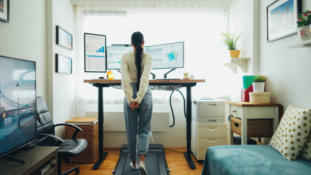 istock Woman at home office is walking on under desk treadmill 1483297073
