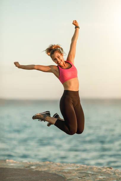 Young fit woman having fun and relaxing after her exercising near to sea.