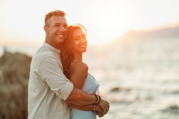 istock Couple In A Hug Enjoying A Sunset At The Beach 1483298404