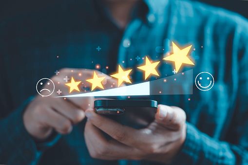 Businessman use smartphone to give five glowing golden stars for excellent evaluation survey after client use product and service from customer satisfaction concept.