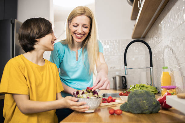 istock Happy woman preparing fresh vegetables with her son 1483299674