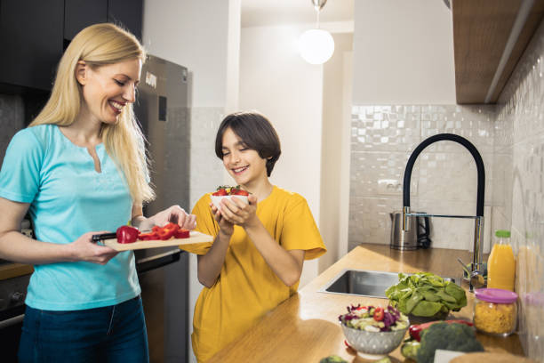istock Happy boy helping his mom to make fresh salad 1483299686