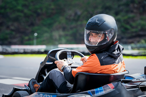 Portrait of professional karting racer on the track .