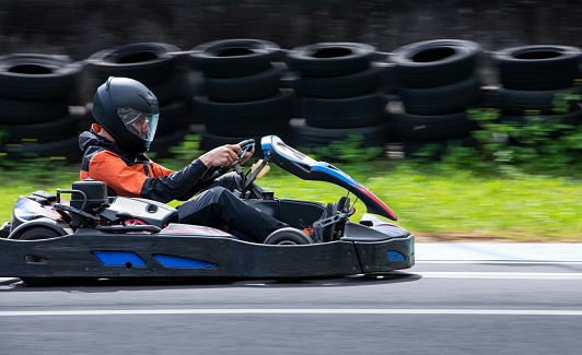 Man racing with a karting car on a sports track and having fun.