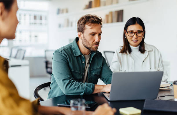 istock Business man using a laptop in a meeting with his team 1483304402