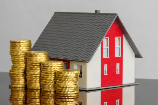 istock Ascending stacks of coins next to a model home 1483304955