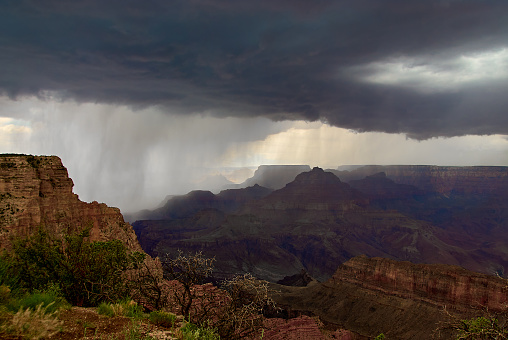 A dramatic photo of a monsoonal thunderstorm dropping a wall of rain over the Grand Canyon on a August afternoon, as seen near Lipan Point on the south rim of canyon in Arizona, USA.