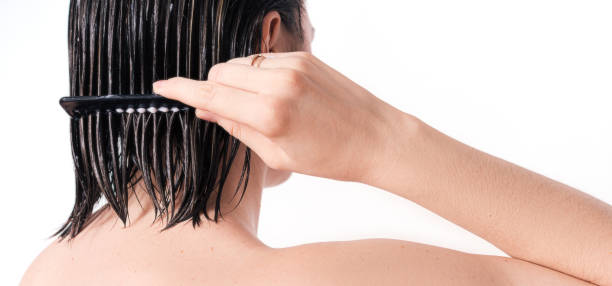istock Lady applying balm to her hair with comb against white background 1483312285