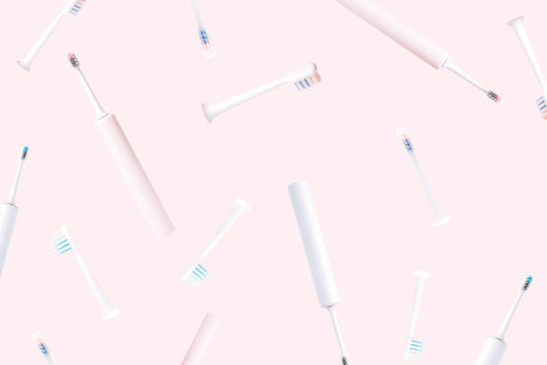 istock Falling electric toothbrushes with nozzles against pink background 1483313690