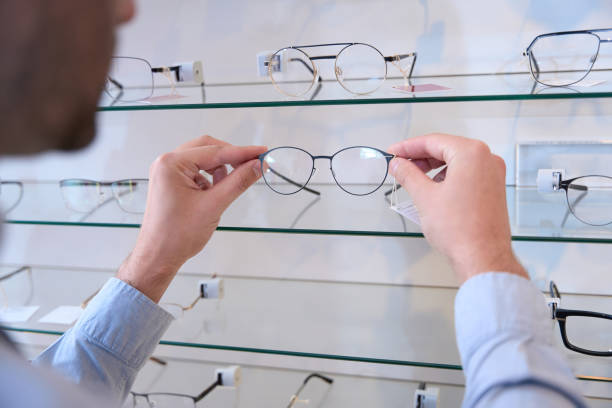 istock Man hands is choosing luxury optician frame in the store 1483314351