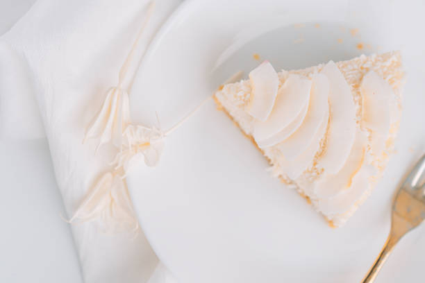 istock White cheesecake with coconut flavor on plate with fork on white background with napkin 1483314401