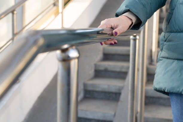 istock woman holding on to the railing going down the stairs 1483314467