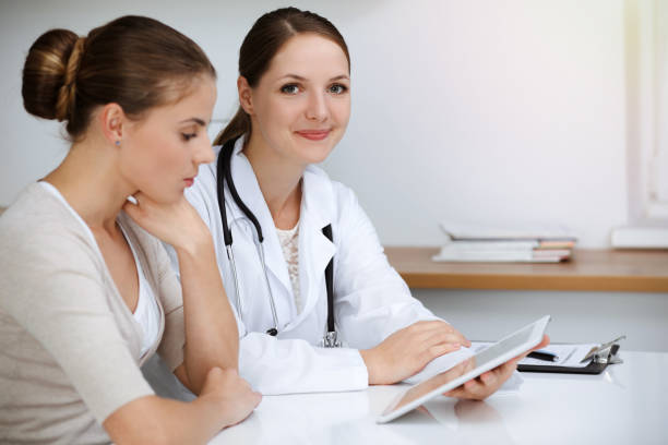 istock Doctor and patient are sitting and discussing health examination results while using tablet computer. Health care, medicine and good news concepts 1483315329