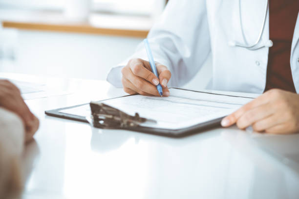 istock Unknown woman-doctor consulting patient and using clipboard with a medication history record. Medicine concept 1483315335