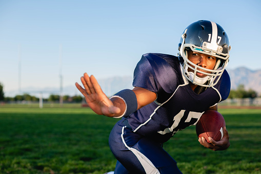 An American Football player and running back in full tackle football pads is ready to play. Image taken in Utah, USA.