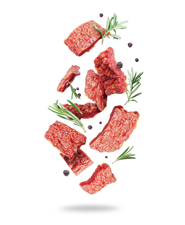 Dried pieces of beef with rosemary in the air isolated on a white background