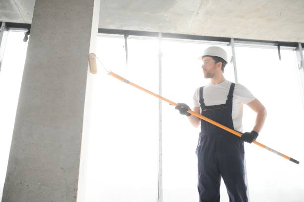 istock Painter man painting the wall, with paint roller. 1483322875