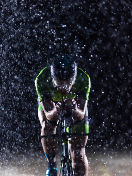 istock A triathlete braving the rain as he cycles through the night, preparing himself for the upcoming marathon. The blurred raindrops in the foreground and the dark, moody atmosphere in the background add to the sense of determination and grit shown by the at 1483323180