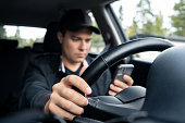 Driving car and using phone to text. Driver using cellphone. Accident, crash and danger in traffic. Man texting with mobile app. Distracted by mobilephone.