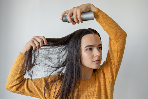 Woman applying hair spray