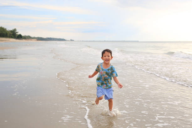 istock Asian little boy having fun running on tropical sand beach 1483324526