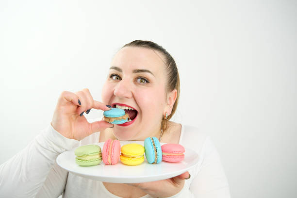 istock Woman eating chocolate macaroons at a restaurant terrace 1483325436