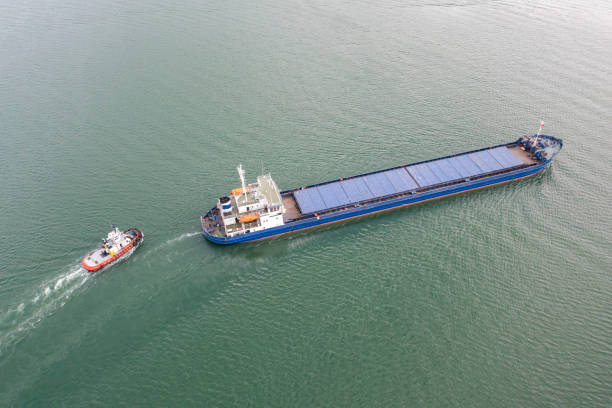 istock Aerial view of Cargo Ship approaching port with tugboat. 1483325775