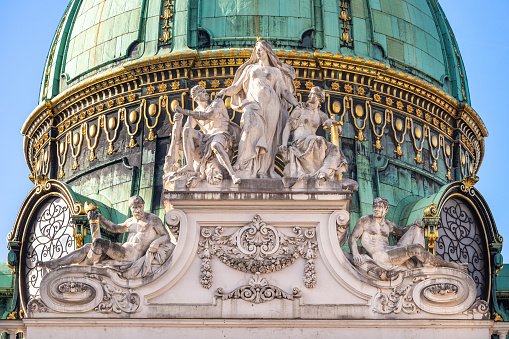 Gilded bronze cupola with marble statues of Michaelertrakt of St. Michael's square exterior facade of Hofburg Imperial palace in Vienna constructed in 1889-1893