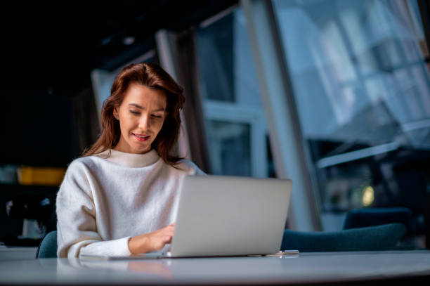 istock Brunette haired businesswoman cheerful smiling and using notebook in a modern office 1483326973
