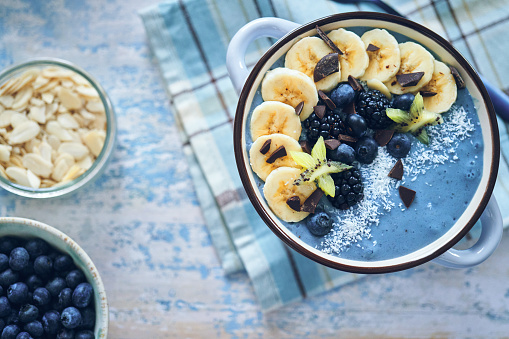 Spirulina Smoothie in Bowl with Banana, Blueberries and Superfoods on Top