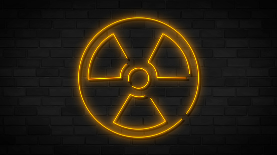 Radiation neon icon. Yellow neon sign on dark brick wall. Best for print, mobile apps and web design.