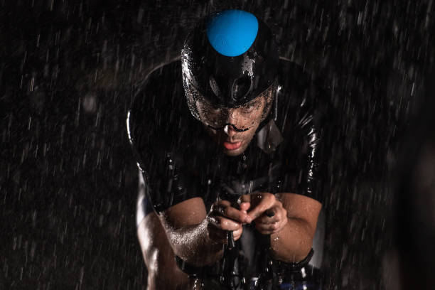 istock A triathlete braving the rain as he cycles through the night, preparing himself for the upcoming marathon. The blurred raindrops in the foreground and the dark, moody atmosphere in the background add to the sense of determination and grit shown by the at 1483332642