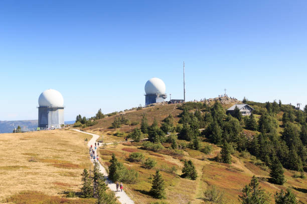 панорама горы гроссер арбер с радиолокационными куполами (обтек�ателями) и вершинным крестом и в баварском лесу, германия - radar dome mountain range mountain hill стоковые фото и изображения