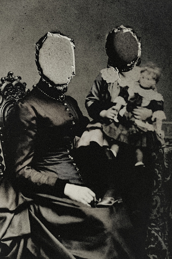 Classic Victorian portrait photo of a mother with daughter. The heads were cut out. Her story is lost. The memory of her destroyed.