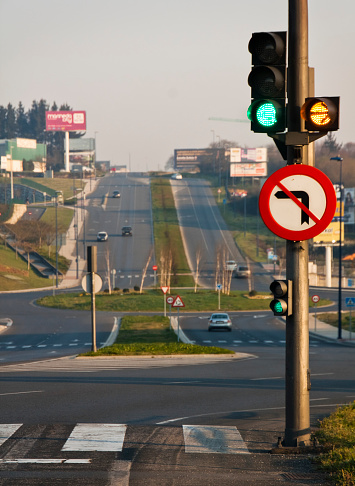 Green traffic light and long straight avenue at dusk, Lugo city, Galicia, Spain.