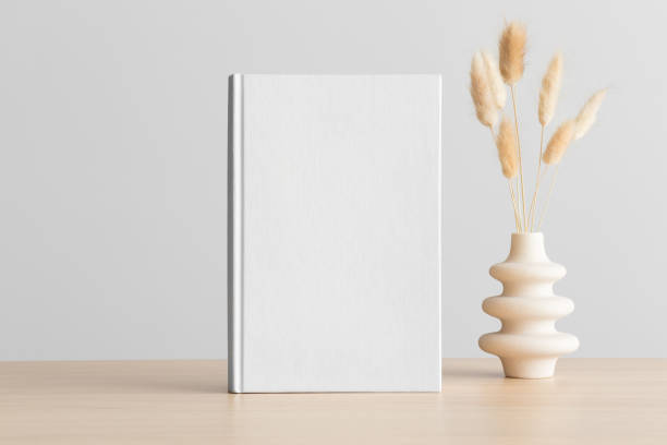 istock White book mockup with a lagurus decoration on the wooden table. 1483337169