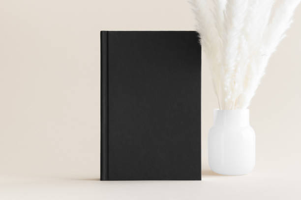 istock Black book mockup with a pampas decoration on the soft yellow background. 1483337182
