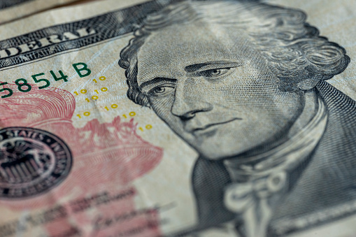 Alexander Hamilton portrait on a ten dollar bill, still life background.