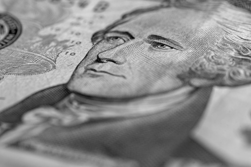 Alexander Hamilton portrait on a ten dollar bill, still life background.