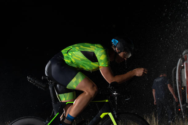 istock A triathlete braving the rain as he cycles through the night, preparing himself for the upcoming marathon. The blurred raindrops in the foreground and the dark, moody atmosphere in the background add to the sense of determination and grit shown by the at 1483339372