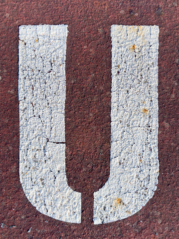 Letter U stenciled on the pavement.