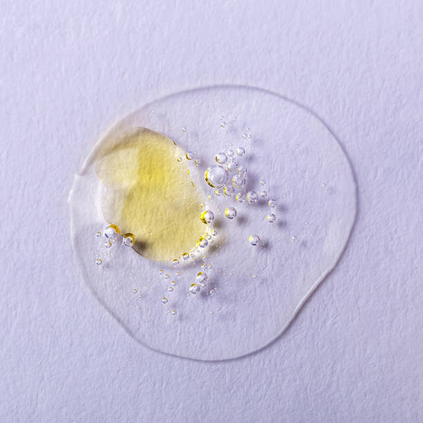 istock Drop of transparent liquid with yellow spot close up 1483343291