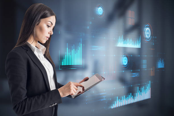 istock Attractive blonde businesswoman using tablet with glowing digital business interface with charts on blurry office interior background. Infographic and big data concept. Double exposure. 1483346492